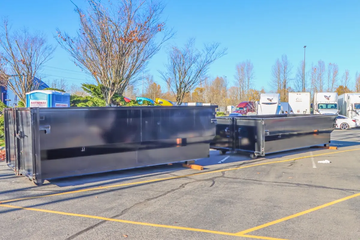 Professional dumpster rental service with roll-off container on residential driveway in Kinston